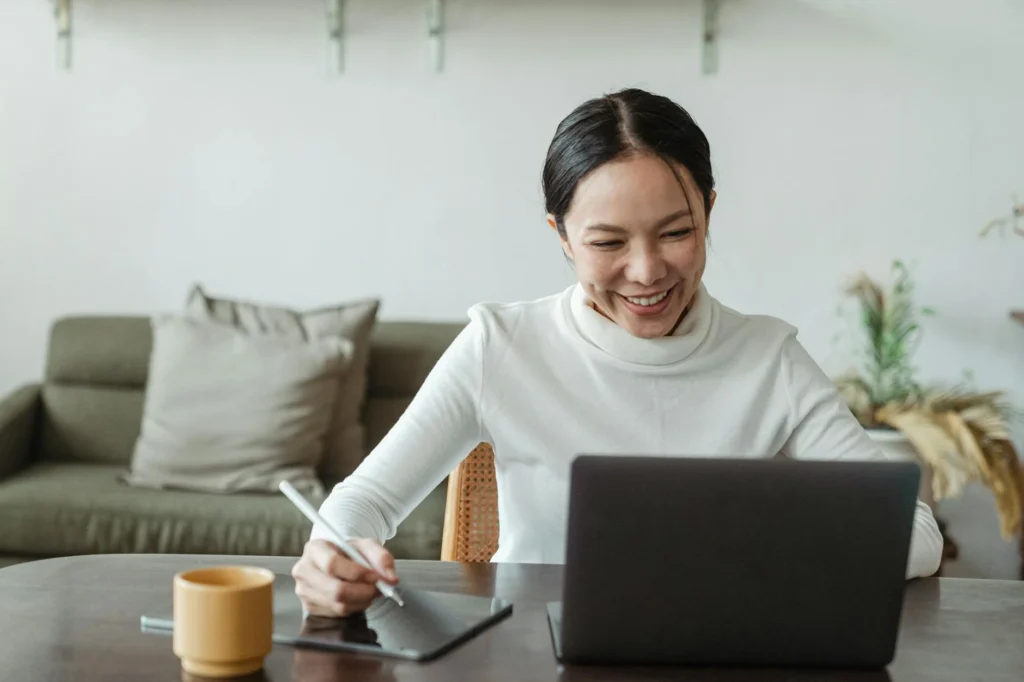 person taking notes while on a virtual meeting